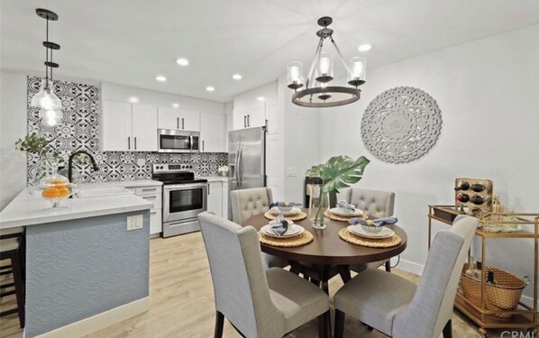 Enjoy cooking and dining in this well-equipped kitchen with a central island and dining area featuring a round table and four chairs.