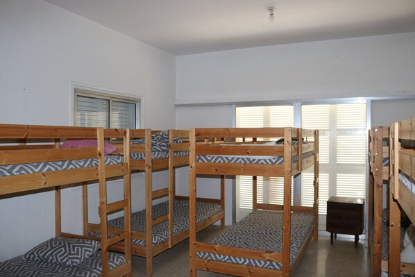 A dormitory room with bunk beds, a window, and a door. - Costas Hostel Action 2 (Nicosia)