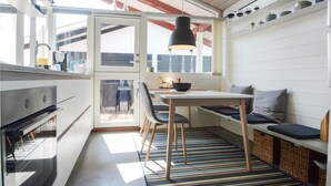 A compact kitchen with a dining area, a large window, and a hanging light fixture. - Lovely home in Aabenraa with kitchen (Aabenraa)