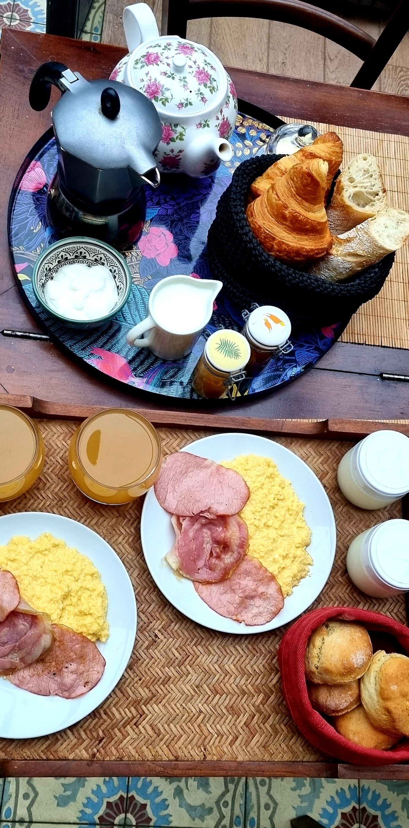 Bandeja de desayuno con tetera, croissants y jarrón de leche.