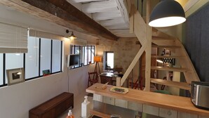 A rustic kitchen with exposed beams, a wooden counter, and a dining area with a table and chairs. - La Dragonne: House with garden, Bellême center, Perche Natural Park value (BELLEME)