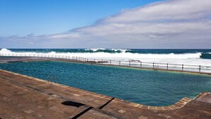 A swimming pool with a view of the ocean and waves crashing onto the shore. - Home2Book Ocean View Bajamar Natural Pool & Beach (Bajamar)