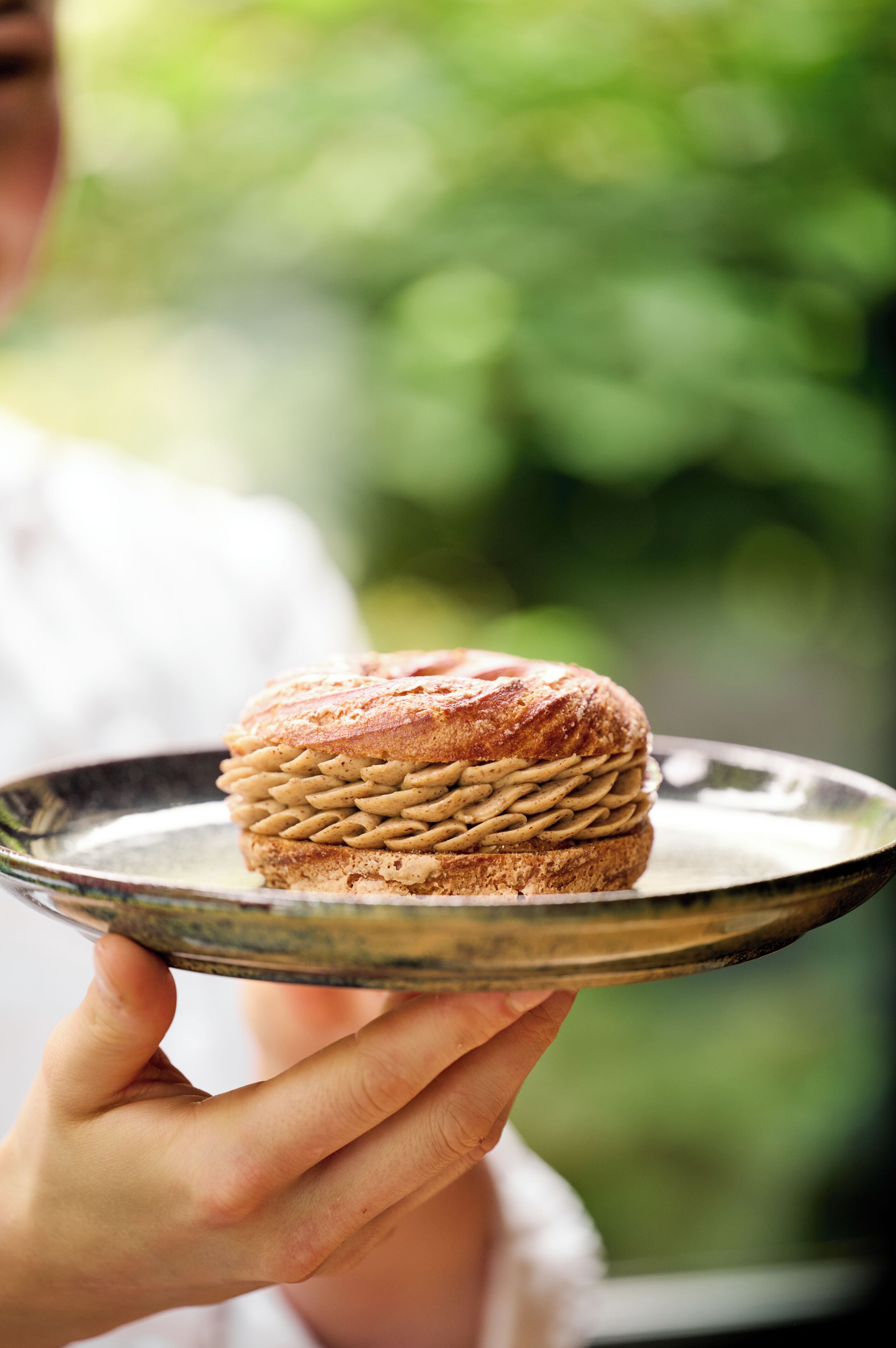 Une personne tenant un plateau sur lequel se trouvent des pâtisseries.