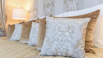 A bed with a quilted headboard and multiple pillows with intricate patterns.