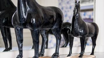 Two black horse sculptures on a marble surface.