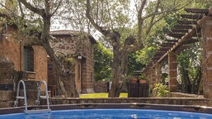 A swimming pool surrounded by stone buildings and trees. - Stunning private villa with WIFI, private pool, TV, patio, pets allowed and panoramic view (Vetralla)