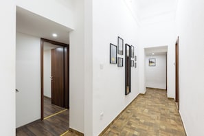 Stunning corridor with framed artwork and two doors leading to comfortable accommodations.