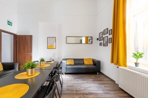 Relax in this stylish room with a comfortable sofa, long table, and large mirror.