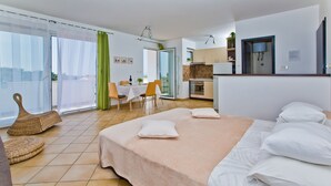 A modern hotel room with a large bed, a dining area, and a kitchen. - Apartments Nina Hvar town (Hvar)