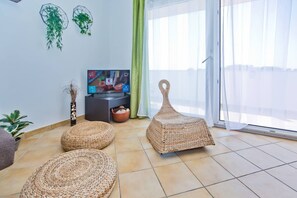 Departamento Confort, Terraza, vista al mar | Área de sala de estar | Televisión LED de 80 cm con canales vía satélite y televisión 