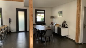 A modern kitchen with a dining area, wooden beams, a large window, and a view of the outdoors. - Villa with pool, close to beaches and town center. (Narbonne)