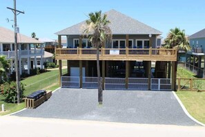 A two-story building with a balcony, a covered walkway, and a parking area. - Pelican Wharf, Pool/Hot Tub (Crystal Beach)
