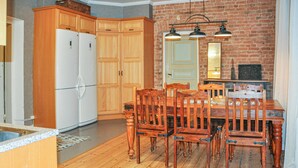 A kitchen with wooden cabinets, a white refrigerator, and a dining table with chairs. - Stunning home in Värmlands Nysäter (Värmlands Nysäter)