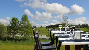 Une table dressée pour le dîner, avec vue sur un lac et des collines.