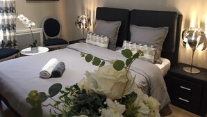 A neatly arranged hotel room with a large bed, two bedside tables, a chair, and a wall-mounted artwork. - 4★ group gîte, ideal for families and groups of friends (Villers-sur-Port)
