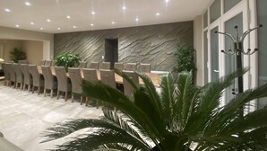 A modern conference room with a long table, multiple chairs, a stone wall, and a large window. - 4★ group gîte, ideal for families and groups of friends (Villers-sur-Port)