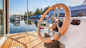 A boat's steering wheel and deck. - Cozy ship in Hennigsdorf with house sea view (Hennigsdorf)