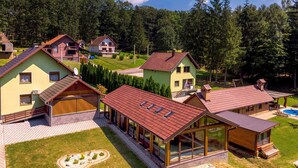 Un quartier résidentiel comprenant plusieurs maisons, dont une grande maison dotée d’un patio couvert et d’une piscine.