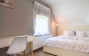 Ein Schlafzimmer mit Bett, Schreibtisch und Stuhl.