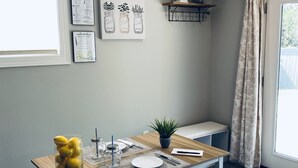 A modern kitchen with a wooden table, bench, and a small potted plant. - Private Nashville Guest Suite - King Bed - Massage Chair - Private Entry (Hermitage)