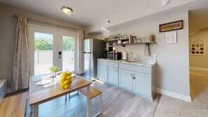 A modern kitchen with grey cabinets, a stainless steel refrigerator, and a microwave on the countertop. - Private Nashville Guest Suite - King Bed - Massage Chair - Private Entry (Hermitage)