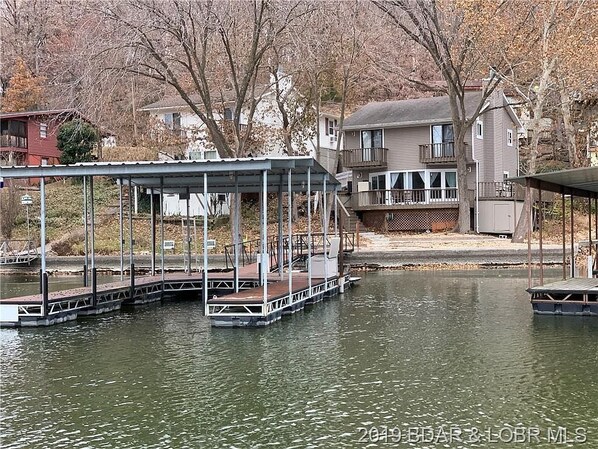 Enjoy serene lakeside views from the covered dock area, perfect for boat access.