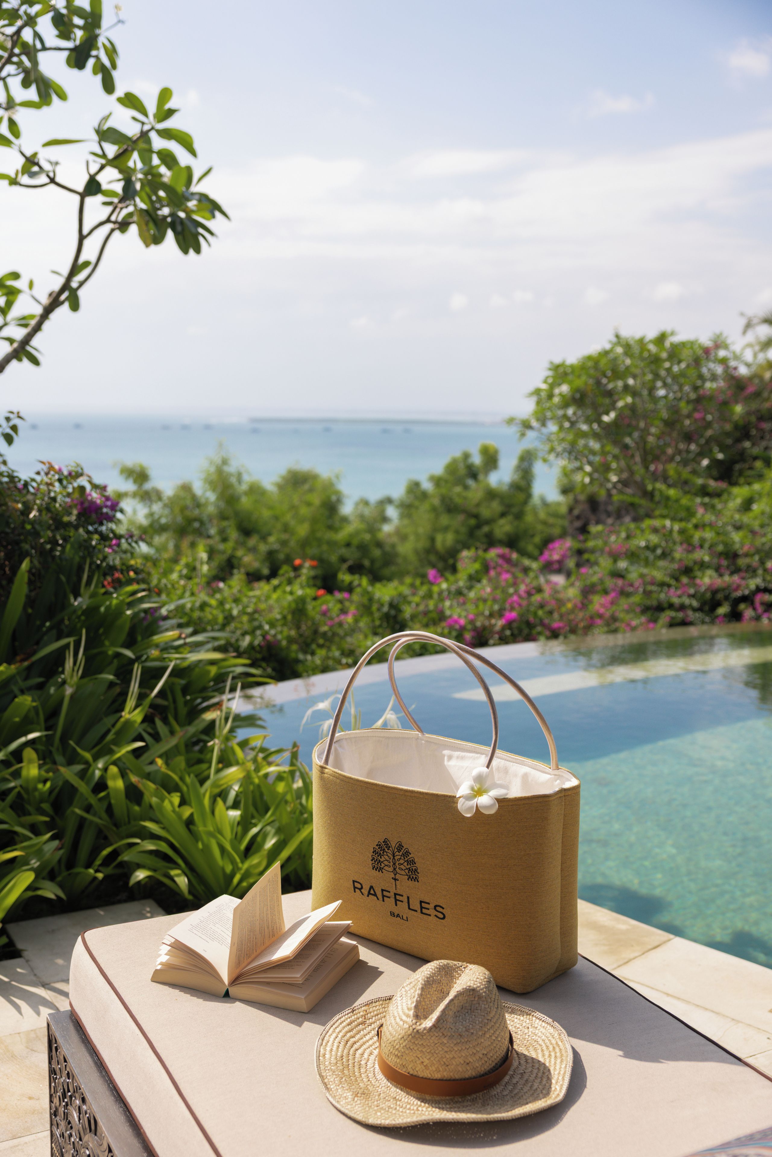 Entorno costero con vista despejada al océano, una piscina y exuberante vegetación.
