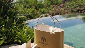 Entorno costero con vista despejada al océano, una piscina y exuberante vegetación.