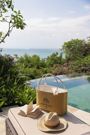 Entorno costero con vista despejada al océano, una piscina y exuberante vegetación.