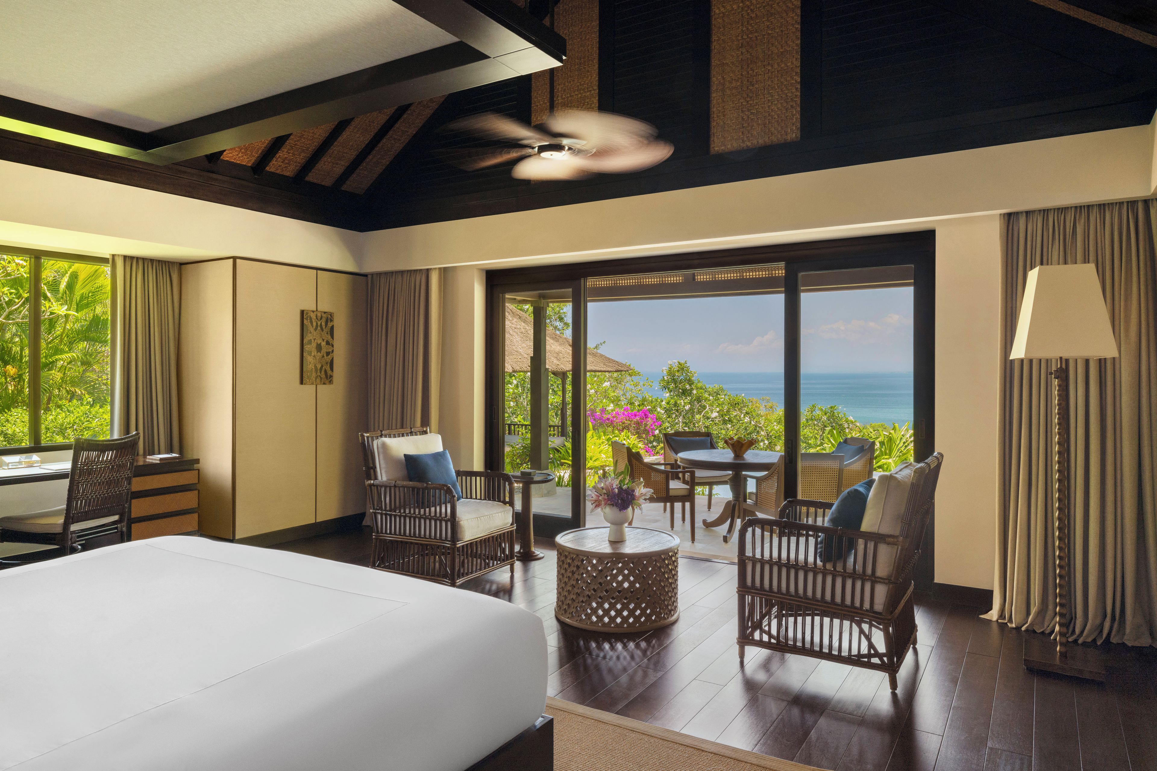 Ein Hotelzimmer mit einem Bett, einer Sitzecke und Blick aufs Meer.