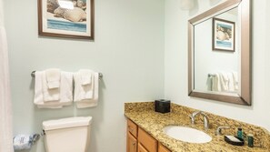 A bathroom with a toilet, sink, and towel rack.