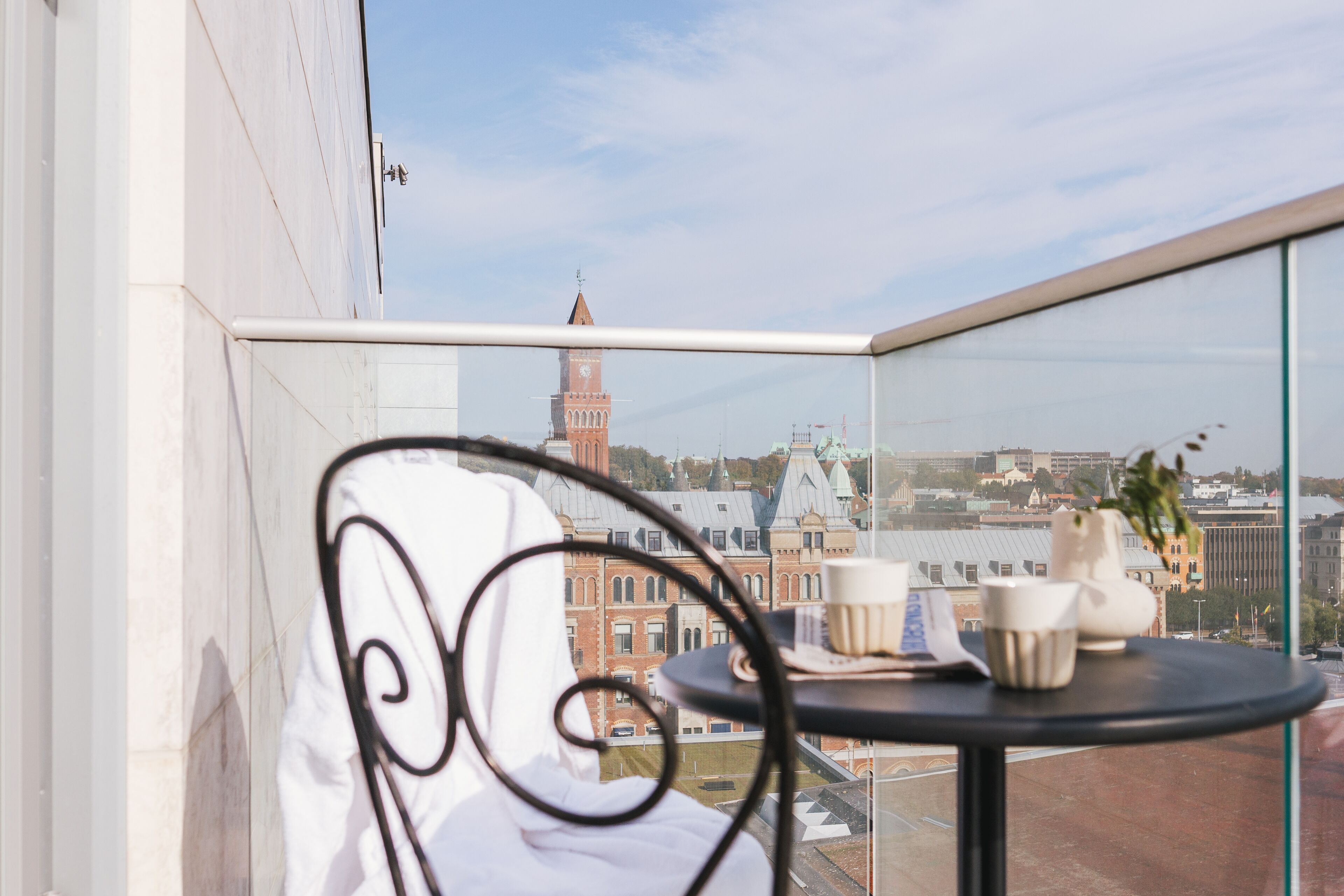 Un balcón con vistas a un edificio histórico y una torre del reloj.