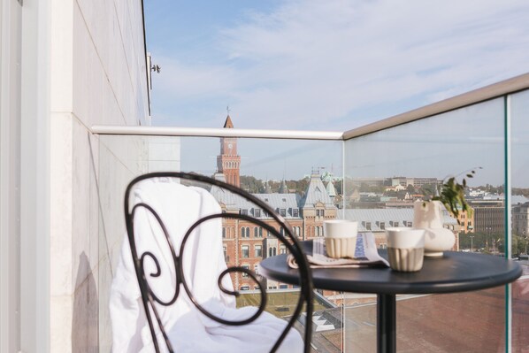 Un balcón con vistas a un edificio histórico y una torre del reloj.