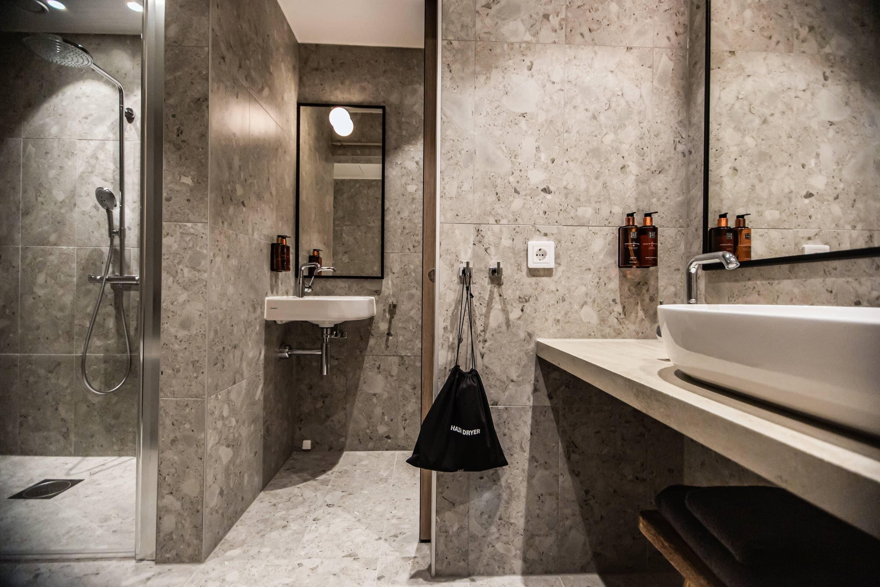 Un baño moderno con ducha, lavabo y espejo.