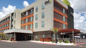 A modern hotel with a stone facade, multiple windows, and a covered entrance.