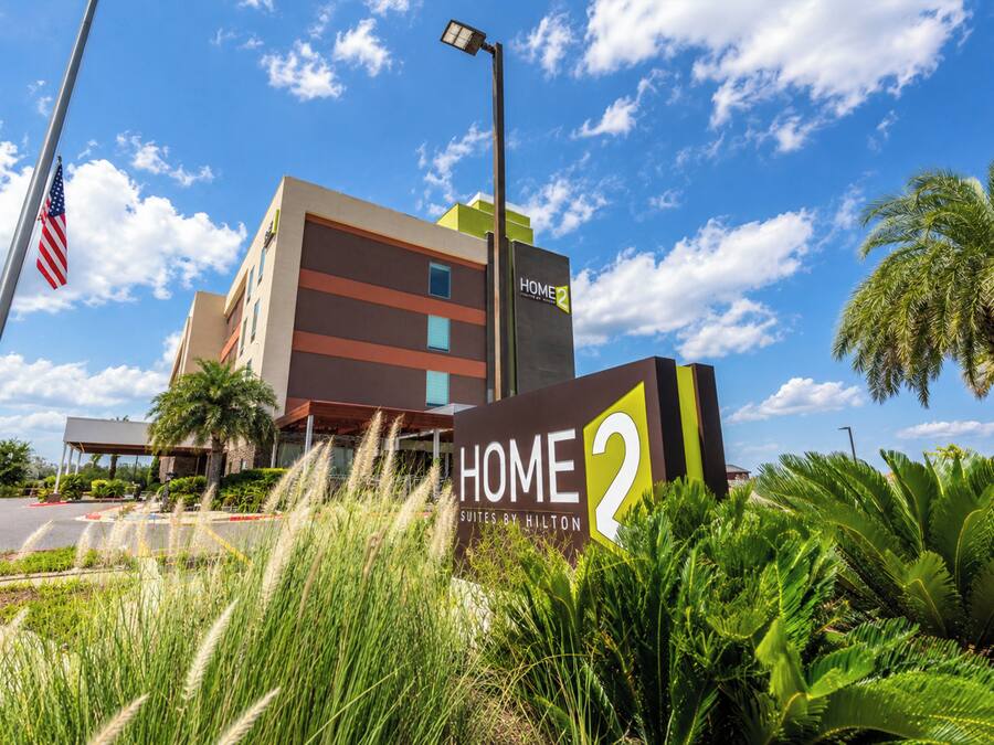 A hotel sign with 'HOME 2' and 'Suites by Hilton' indicating a Hilton hotel.