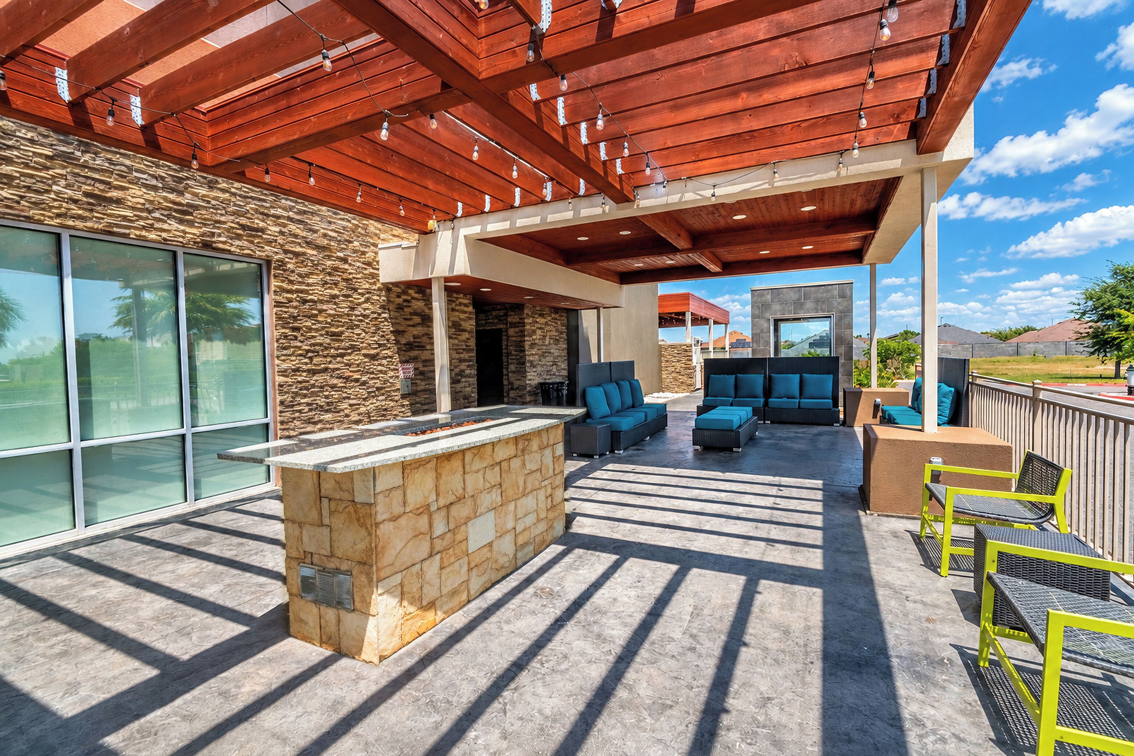 An outdoor patio area with stone walls, a bar, and seating arrangements.