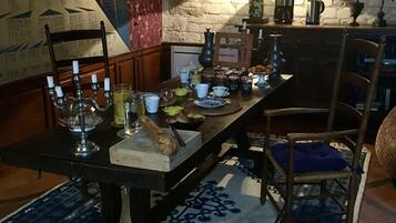 A dining table set with candles, plates, and a bread loaf.