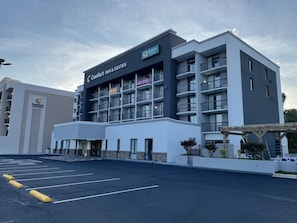 Contemporary hotel building with a modern design, featuring a prominent hotel name and multiple balconies.