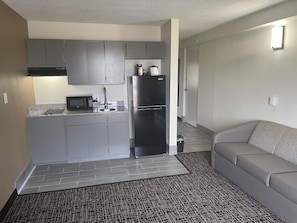 Cozy living space with a kitchenette, sofa, and patterned rug.