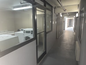 Experience the simplicity of this modern hallway with doors, windows, and a convenient laundry area.