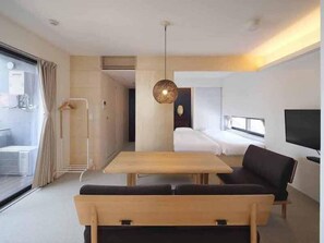 A modern hotel room with a large bed, a TV, and a dining area. - East SQUARE Tokyo (Tokyo)