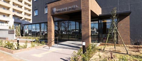 Exterior del Hotel Shinrin, con un diseño moderno, que presenta fachada de ladrillo y grandes ventanales.