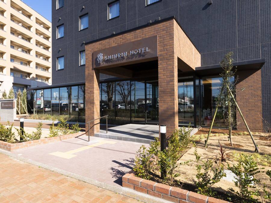 Exterior del Hotel Shinrin, con un diseño moderno, que presenta fachada de ladrillo y grandes ventanales.