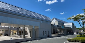 A modern building with a flat roof, large windows, and a covered entrance area.