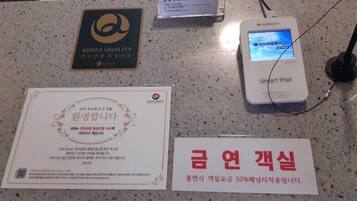 Una encimera con un cartel de Korea Quality, un dispositivo Smart Pad y un certificado.