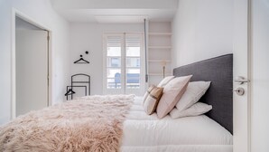 Ein Schlafzimmer mit einem Bett, einer flauschigen Decke und Kissen.