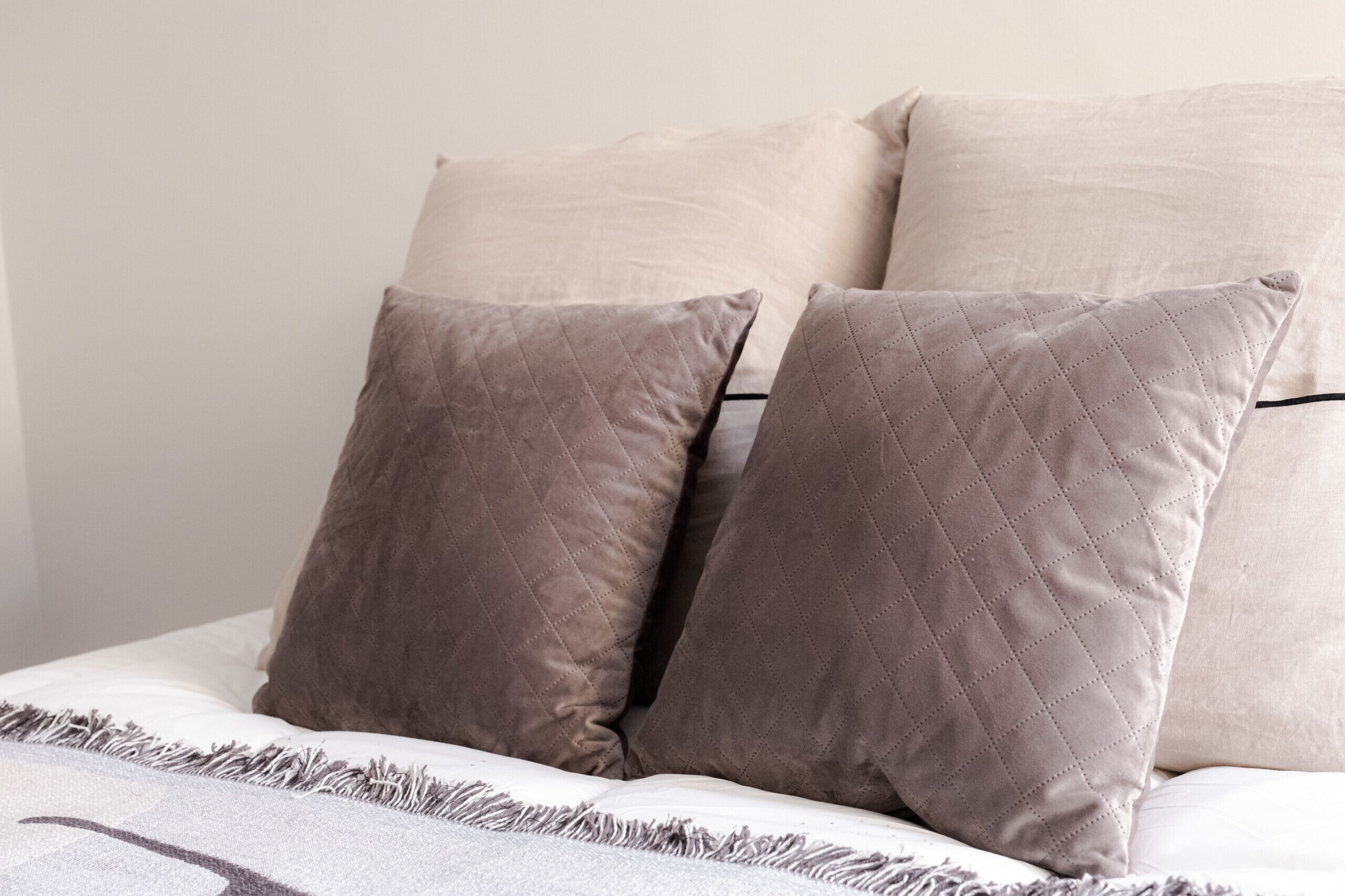 A bed with two pillows and a blanket.