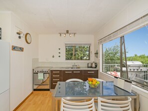 Cocina compacta con comedor, ventana con vistas y una parrilla en el exterior.