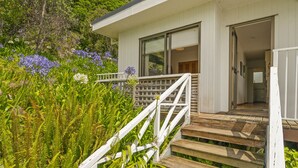 A white building with a wooden staircase leading to a balcony. - Double the Beach - Opito Bay Holiday Home (Opito Bay)